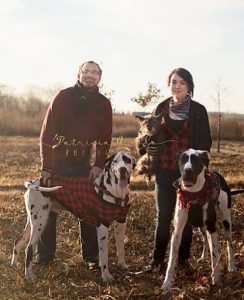 Picture of Man and wife with their three dogs in a field